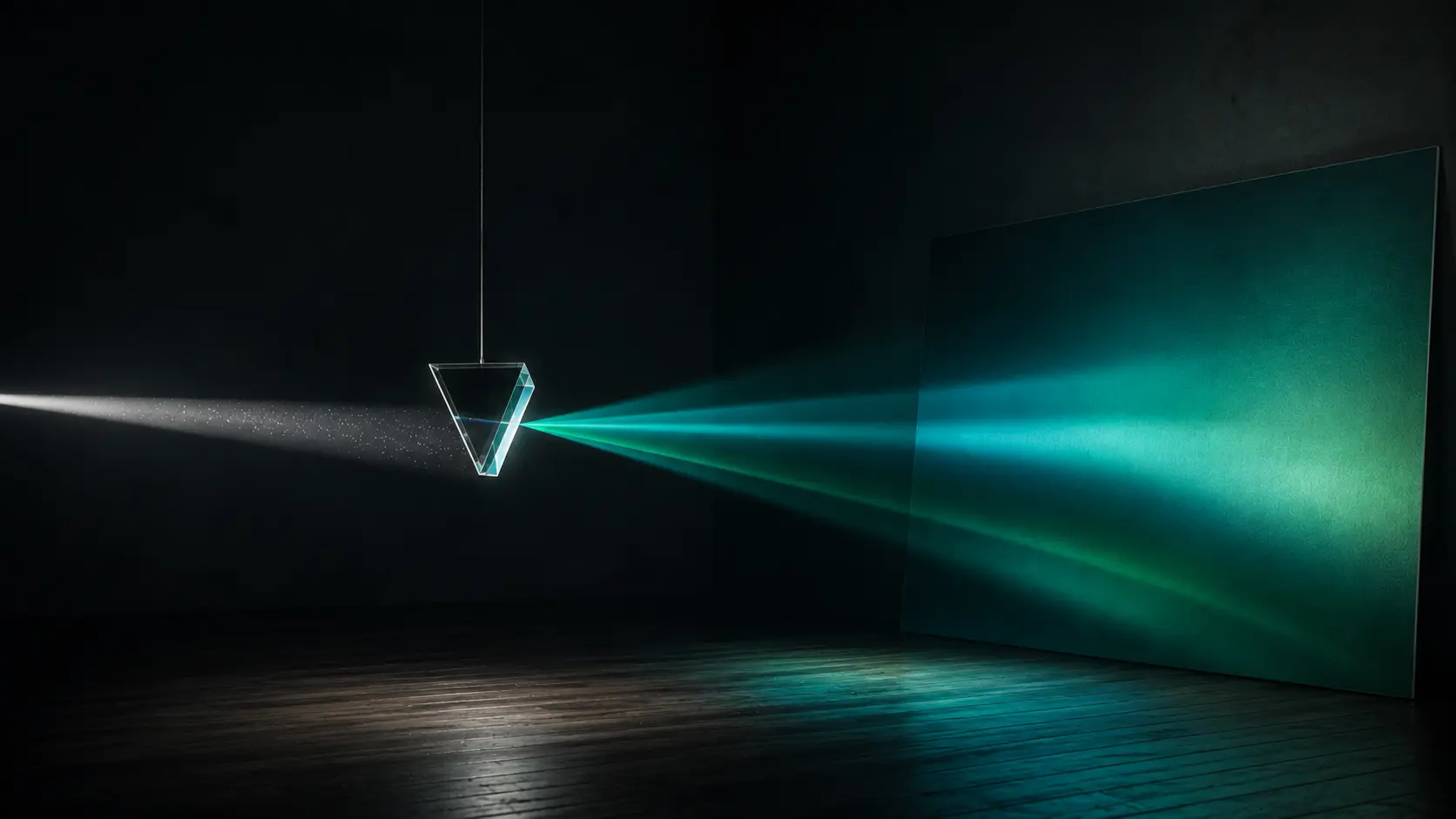 A glass prism suspended in a dark room, bending white light into teal and green beams projected onto a wall.